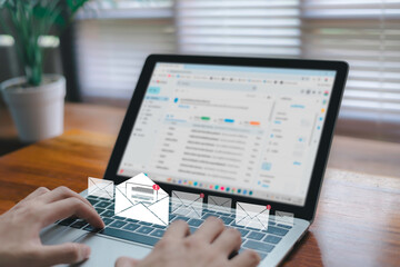 A business person is typing on a laptop with an email notification icon overlaid, illustrating concepts related to online communication, productivity, digital marketing, and remote work.