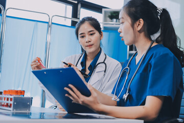 Medical team meeting analyzing blood test results in hospital laboratory. Doctors and scientists in lab coats are having a discussion about blood test result, holding test tubes and taking notes.
