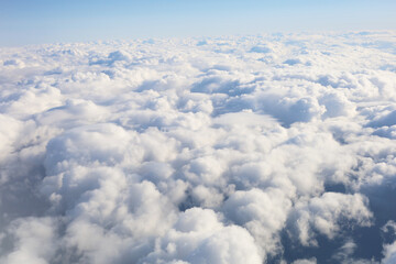 Aerial view of fluffy clouds seen from an airplane window flight.