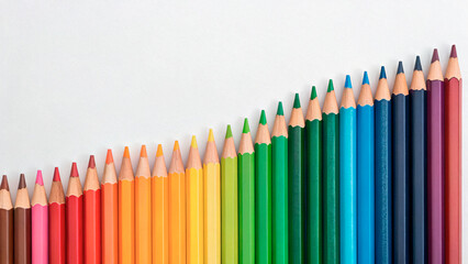 Different colors of pencils arranged in a wave pattern on a white background in a simple design layout