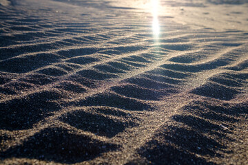光を受けて輝く砂浜のうねり
