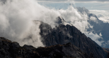 Rocky mountain peaks shrouded in mist and clouds. Tre cime dolomite Italy