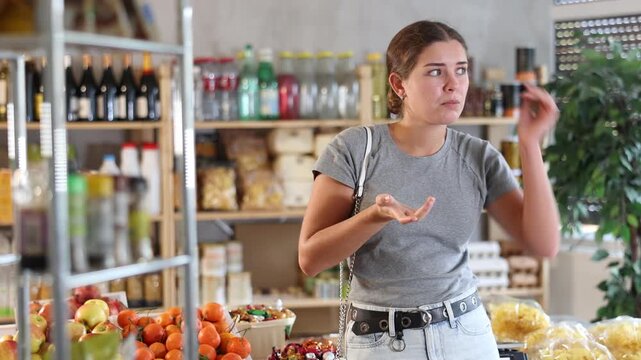  Young woman buyer forgot what she wanted to buy at grocery store