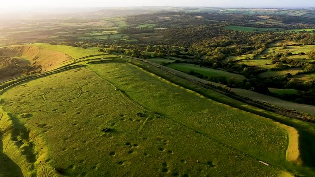 Eggardon Hill multivallate Iron Age hillfort, Dorset. Visible hut site depressions and Bronze Age linear earthworks and bowl barrow. Octagon is recent. Video fly up back from east entrance