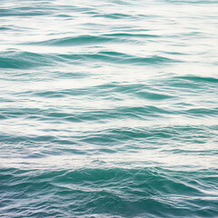 Obraz premium Close-up shot of gentle turquoise water waves, showing the shimmering surface and the dynamic movement of the ocean in natural daylight