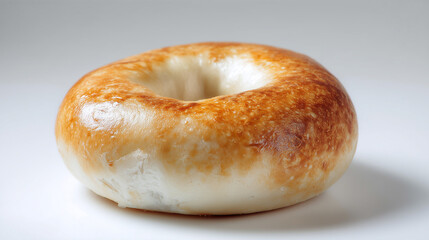 表面がツヤツヤと輝きこんがりとした焼き色が美しいシンプルなプレーンベーグルのクローズアップ