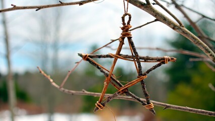 Crafting a star decoration from twigs in winter outdoors at a rural location