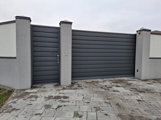 Beautiful new door and sliding gate for a car at the entrance to the cottage