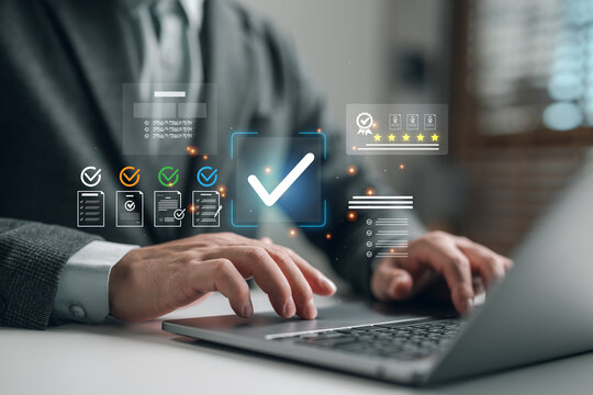 Businessman using laptop to manage digital checklist and quality assurance system, verifying tasks and documents for approval with high rating and compliance interface. - Powered by Adobe