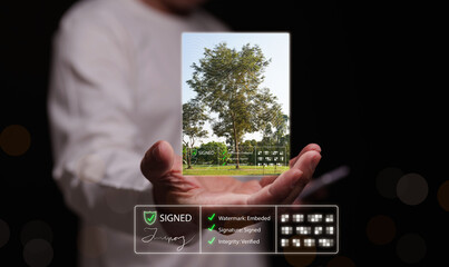 Man holding a verified digital photograph with a watermark, signature, hash, integrity checklist. Secure online asset authentication, trusted photo ownership, cybersecurity, and copyright protection.