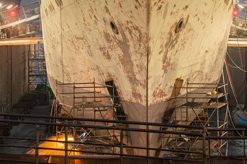 three-masted sailing ship in dry dock during repairs at the shipyard