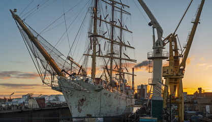 three-masted sailing ship in dry dock during repairs at the shipyard