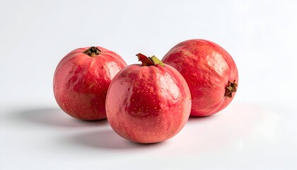 Three ripe, reddish-pink fruits with textured skin on a white surface