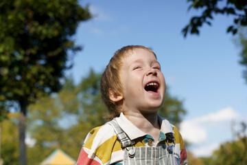 Portrait of a Cheerful Laughing Three-Year-Old Toddler Boy Outdoors