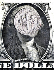 Close-up of a US one dime coin placed over George Washington&rsquo;s face on a dollar bill. Concept of money, finance, economy, and currency value.