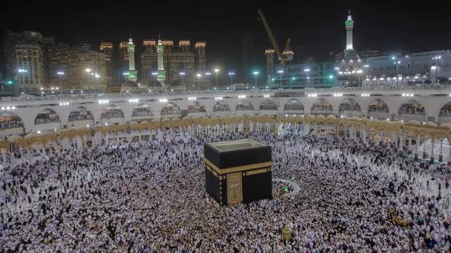 Kaaba Mecca mosque at night surrounded by pilgrims