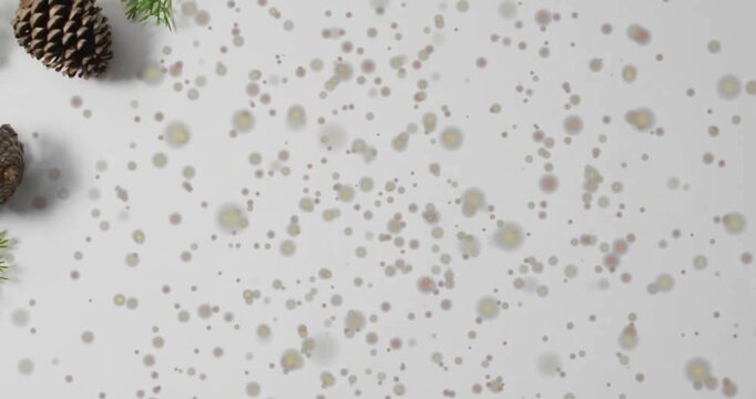 Animation of spots of light over christmas pine cones decorations with copy space