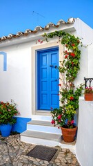 A charming doorway with a bright blue door, surrounded by lush green foliage and vibrant red flowers, in a sunny setting