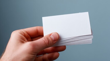 Hand holding blank business cards over a white background for corporate branding, professional identity, marketing presentation, and office stationery concept