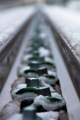 Rail fasteners covered in winter snow creating symmetry