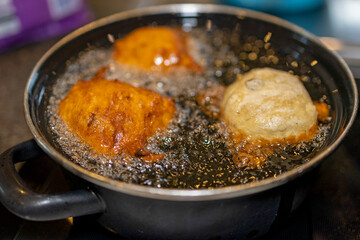 Delicious oliebollen slowly cooking to golden perfection in hot oil
