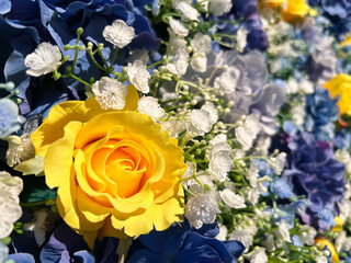 日差しを浴びる黄色のバラの造花