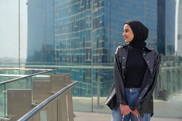 Young muslim woman with hijab in front of the modern building