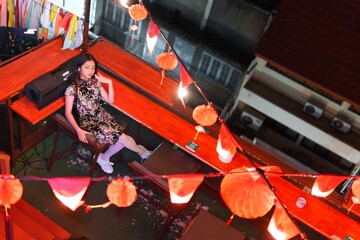 New Year Celebration with Girl Sitting Among Lanterns and Decorations
