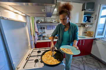 Woman serving omelette onto plate © Xalanx