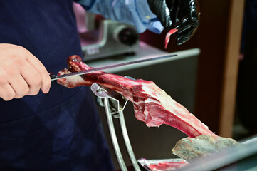 Man Slicing Spanish Jamon with Knife