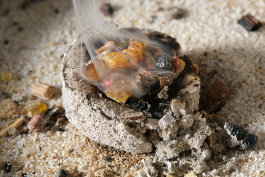 Burning incense resins on glowing charcoal with rising aromatic smoke