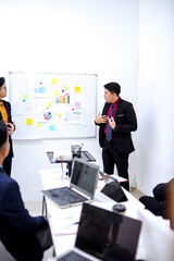 Businessman Confidently Presents Data To Colleagues In Modern Office Setting