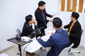 Professionals In Business Attire Engaged In Meeting, Discussing Strategy And Reviewing