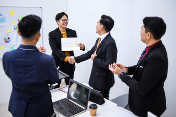 Confident Businessmen Celebrating Success With Handshake In Modern Office Setting