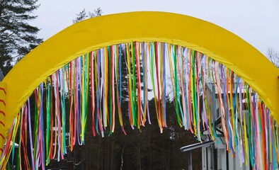 Multicolored ribbon decorations on the Maslenitsa arch. Welcoming spring, bidding farewell to winter.