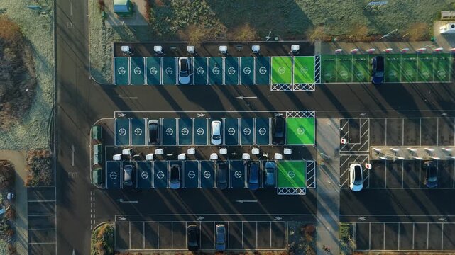 Top down aerial view of EV electrical vehicle charging hubs, modern car technology, no fossil fuels at a service station in the United Kingdom.
