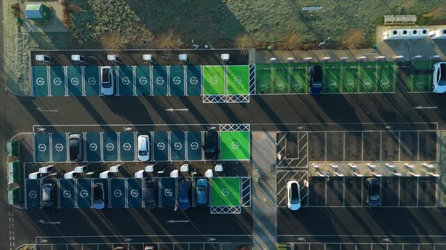 Top down aerial view of EV electrical vehicle charging hubs, modern car technology, no fossil fuels at a service station in the United Kingdom.