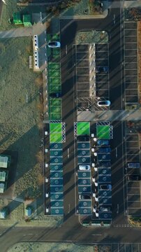 Top down aerial view of EV electrical vehicle charging hubs, modern car technology, no fossil fuels at a service station in the United Kingdom.