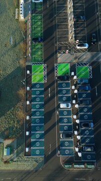 Top down aerial view of EV electrical vehicle charging hubs, modern car technology, no fossil fuels at a service station in the United Kingdom.