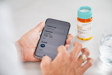 Woman checking her medication schedule on a mobile device to manage daily pills. Captures clarity, steady routine, and disciplined health monitoring.