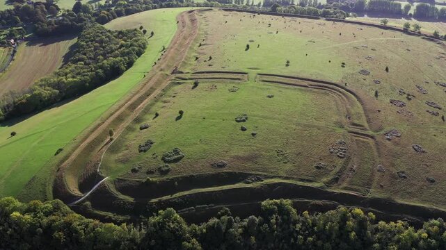 E over Hod Hill Iron Age hillfort. Blackmore Vale, Dorset. Main rampart dates from 500 BC. Once home of the Durotriges. Later Roman fort in NW corner. Video fly up back from Roman fort