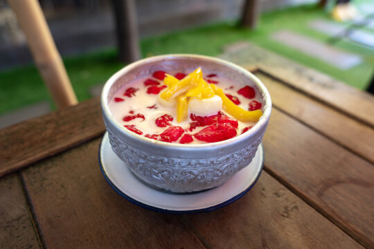 Close up of a Thai dessert called "Ruam Mit". It is served with water chestnut, jackfruit and jelly dipped in coconut milk. Ice is optional.