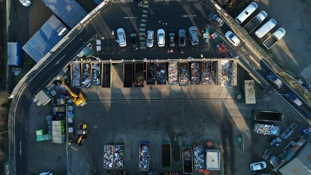 Top down aerial view of recycling centre, garbage disposal and rubbish tip, cars unloading refuse and waste in to skips, Rugby United Kingdom. 