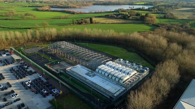 Aerial drone footage of large scale data center with cooling fans and quantum AI computing near Birmingham United Kingdom