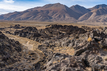 Volcanic rock, Basalt flows. Fossil Falls Trail, Coso Volcanic Field, Inyo County, California.  Coso Range, Basin and Range Province. In the distance is Sierra Nevada ( mountain range )