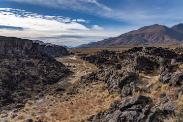 Volcanic rock, Basalt flows. Fossil Falls Trail, Coso Volcanic Field, Inyo County, California.  Coso Range, Basin and Range Province. In the distance is Sierra Nevada ( mountain range )