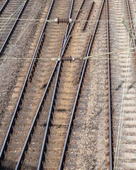 Train tracks diverging in a busy railway area during the daytime highlighting the complex network...