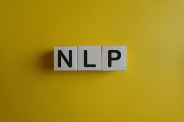 Three white tiles with letters N L P on a yellow background