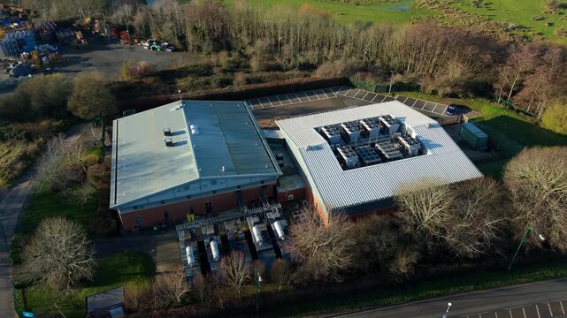 Top down aerial drone view of critical data center infrastructure with HVAC cooling fans and rooftop units supporting quantum computing cloud storage in Redditch UK