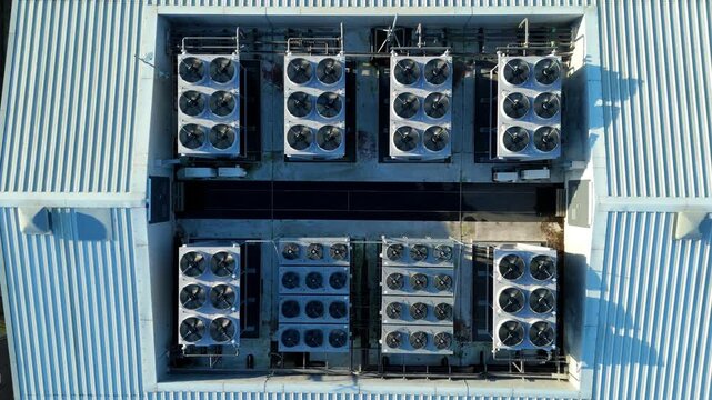Top down aerial drone view of critical data center infrastructure with HVAC cooling fans and rooftop units supporting quantum computing cloud storage in Redditch UK